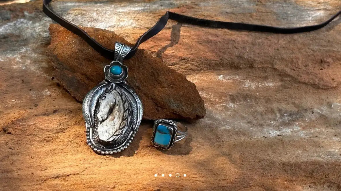 Silver and turquoise stone pendant necklace with a black cord.